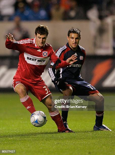 Stephen King of the Chicago Fire kicks the ball away from Gary Flood of the New England Revolution during the first half at Toyota Park on April 3,...