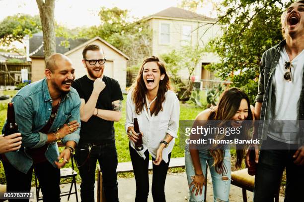 laughing  friends in backyard on summer evening - summer comedies party stockfoto's en -beelden