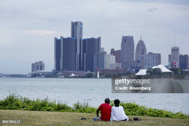 Couple sits on Belle Isle while looking at the skyline in Detroit, Michigan, U.S., on Thursday, June 22, 2017. To lure more young talent straight out...