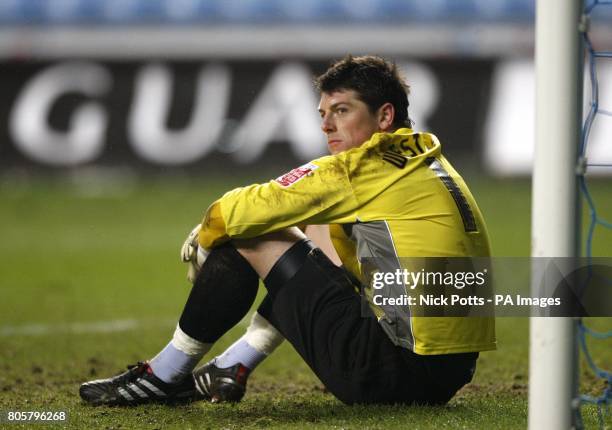 Coventry City goalkeeper Keiren Westwood sits dejected after teammate Stephen Wright scores a late own goal to make the score 1-1