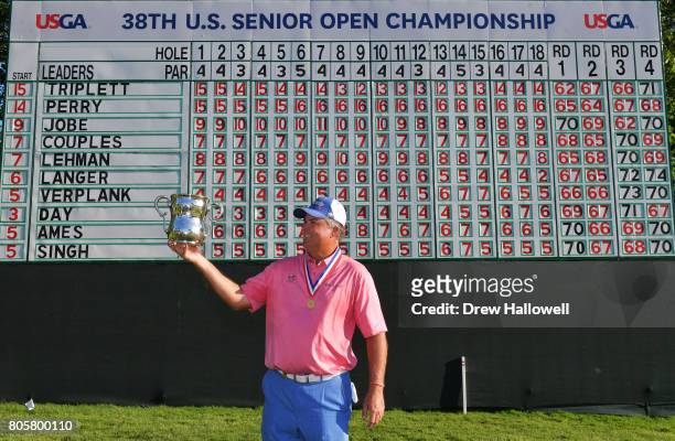 Kenny Perry stands in front of the final leaderboard, while holding the Francis D. Ouimet Memorial Trophy after winning 2017 U.S. Senior Open...