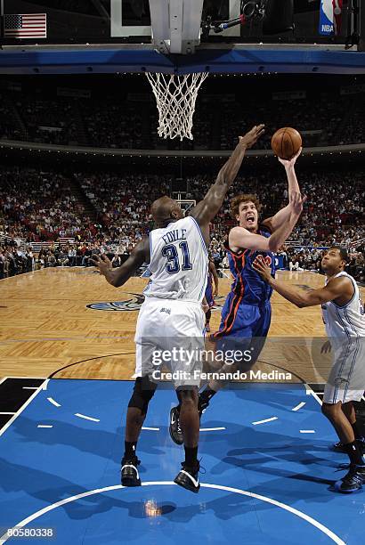 David Lee of the New York Knicks shoots against Adonal Foyle and Brian Cook of the Orlando Magic during the game at Amway Arena on March 1, 2008 in...