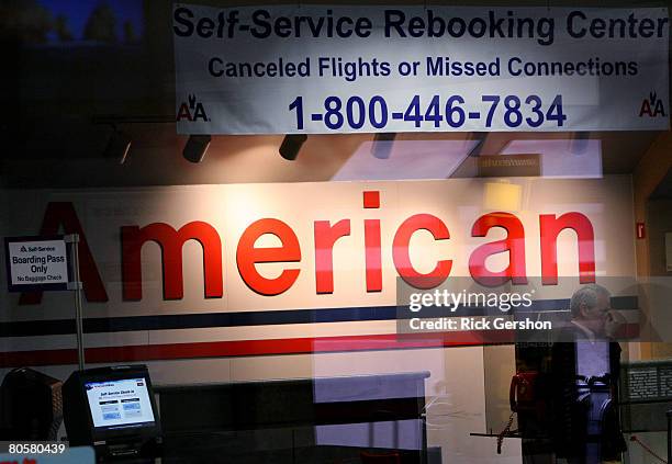 Stranded traveler uses the courtesy phone at a self service rebooking center in a terminal April 9, 2008 at the Dallas Fort Worth International...