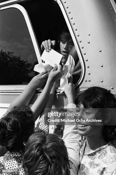 Fans mob the tour bus an beg for aurtographs from The Dave Clark Five on a tour to promote their movie "Having A Wild Weekend" in August 1964 in New...