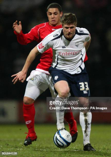 Preston's Neil Mellor and Barnsley's Nathan Doyle battle for the ball during the Coca-Cola Football League Championship match at Deepdale, Preston.