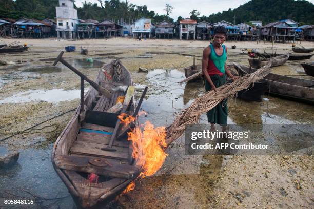 This picture taken on May 13, 2017 shows a member of the Moken tribe using fire to repair his boat in Makyone Galet village in the Myeik Archipelago,...