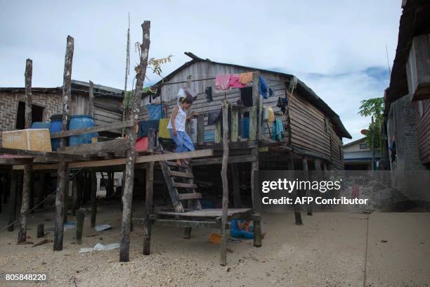 This picture taken on May 13, 2017 shows a member of the Moken tribe descending from a stilt home in Makyone Galet village in the Myeik Archipelago,...