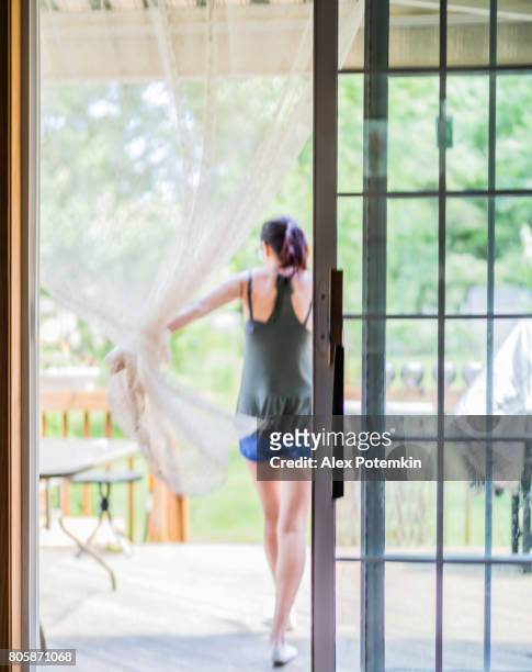 den 15 år gammal tonåring flicka lämnar huset, gå till verandan, passerar genom glaset glidande dooк stängt av courtain - sliding door bildbanksfoton och bilder