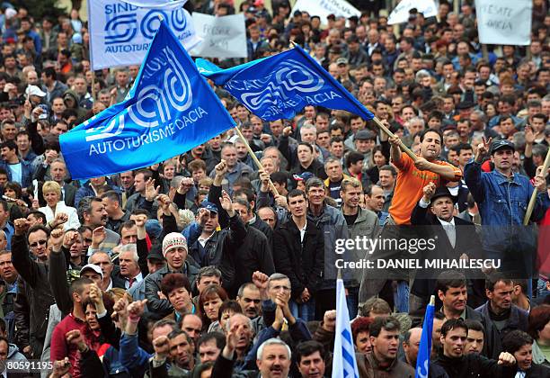 Workers wave trade-union flags and shout slogans as they protest in Pitesti, some 120km northwest from Bucharest, during a strike of the French-owned...