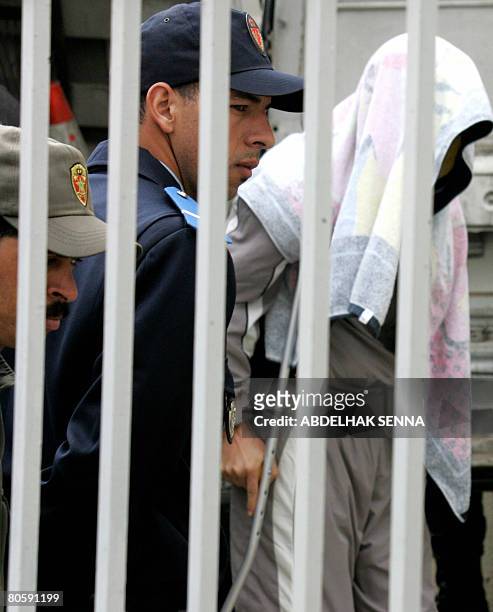 Hicham Doukkali, accompanied by policemen arrives at the court in Sale, near Rabat on April 10, 2008. Hicham Doukkali got injured on August 13, 2007...