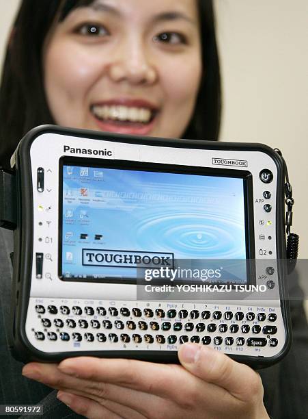 An employee for Japanese electronics giant Matsushita Electric Industrial displays the prototype model of the heavy-duty handheld PC "Toughbook",...