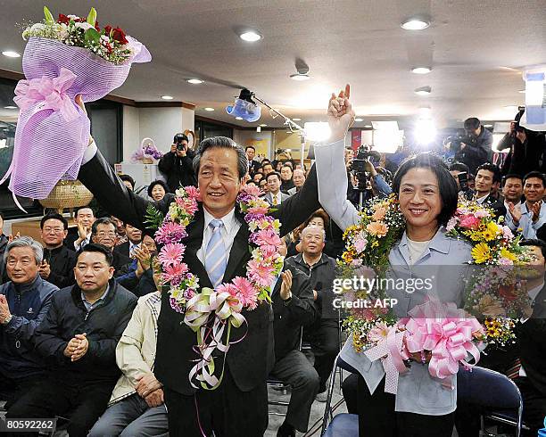 Billionaire politician Chung Mong-Joon of the conservative Grand National Party and his wife Kim Young-Myung hold up their hands in a sign of victory...