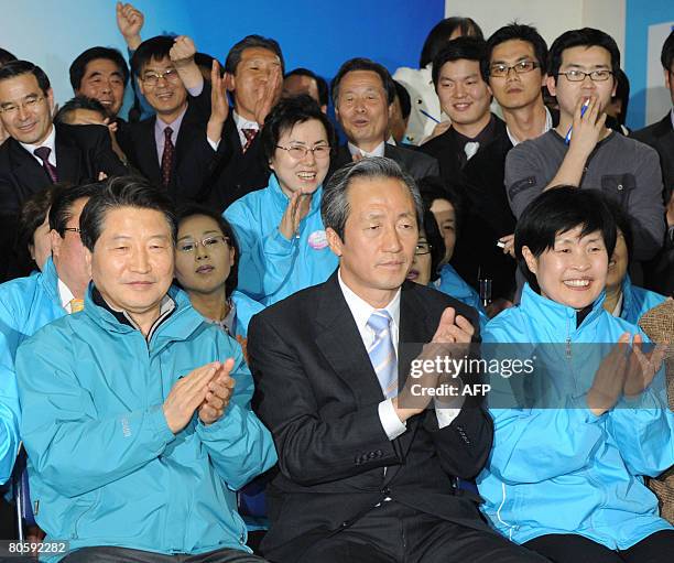 Billionaire politician Chung Mong-Joon of the conservative Grand National Party and supporters clap while watching vote counting on television at his...