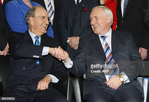 Irish Prime Minister Bertie Ahern and former US senator George Mitchell shake hands during a photocall at the BBC studios, in Belfast, Northern...