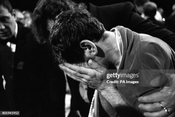 Pat Cowdell is led away sobbing after he was knocked out in the 1st round of his featherweight match with Azumah Nelson, who was defending his WBC...