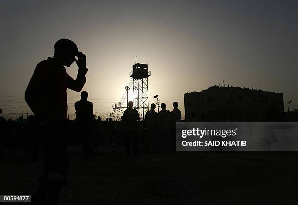 Palestinian youths are silhouetted during a protest against the Israeli siege on the Gaza Strip at the Rafah border point between Egypt and Gaza on...