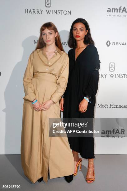 Thais Klapsisch and Annabelle Ferrera pose during a photocall, as part of a dinner organized by the foundation for AIDS research amfAR on July 2,...