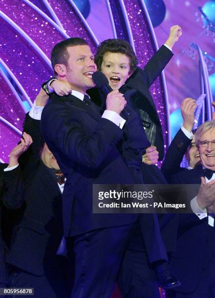 Demot O'Leary hold up young actor, Alex Bain, as members of the Coronation Street cast collect the best Serial Drama award during the National...