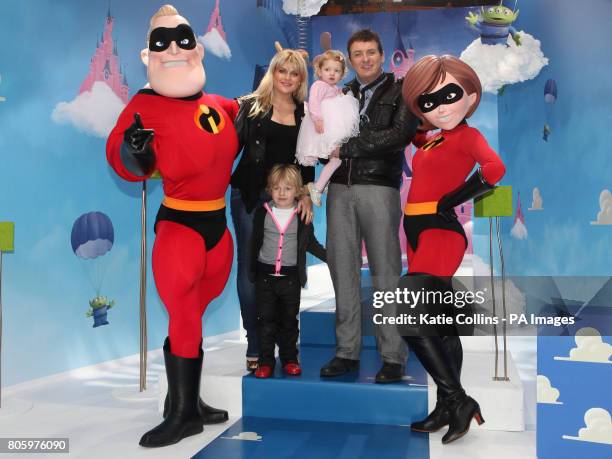 Shane Richie holding daughter Lolita Bell with his wife Christie Goddard and son Mackenzie Blue with people dressed as the Disney characters Mr and...