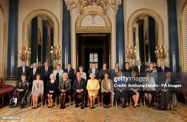 Britain's Queen Elizabeth II and the Duke of Edinburgh pose with Civil Service Commissioners before a reception at Buckingham Palace, London. They...