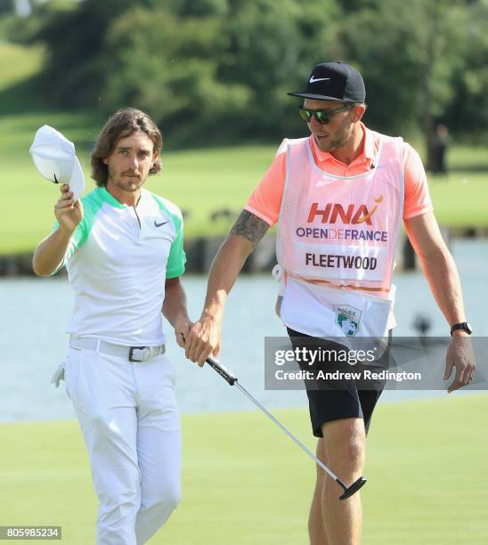 Tommy Fleetwood of England celebrates with hcaddie Ian Finnis on the 18th hole during the final round of the HNA Open de France at Le Golf National...