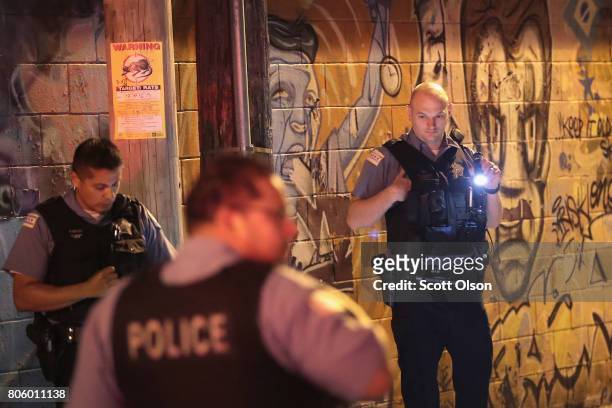 Police search for evidence after a man was shot in the Little Village neighborhood on July 2, 2017 in Chicago, Illinois. Five people were killed and...