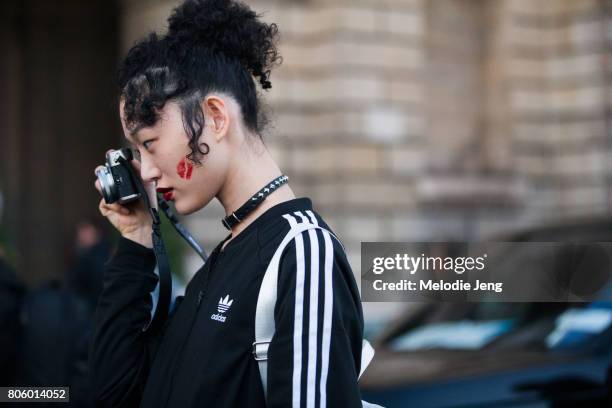 Sora Choi takes a photo and has a kiss mark on her cheek outside the Miu Miu Cruise 2018 show on July 2, 2017 in Paris, France.