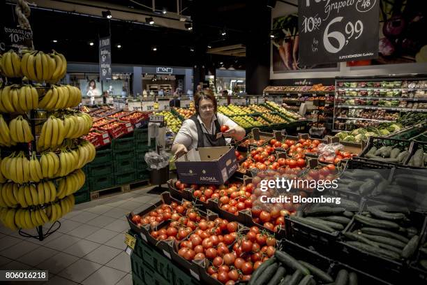 An employee unpacks tomatoes into the fresh produce aisle inside a Super Konzum supermarket, operated by Agrokor dd, in Zagreb, Croatia, on Tuesday,...