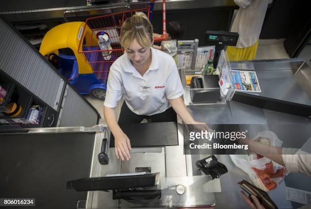 Customer hands an employee a Croatian fifty kuna banknote at the checkout area inside a Super Konzum supermarket, operated by Agrokor dd, in Zagreb,...