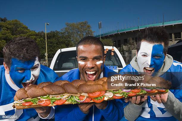 hungry fans with sandwich - big sandwich stock pictures, royalty-free photos & images