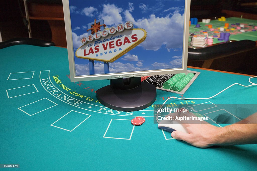 Hand using computer on betting table
