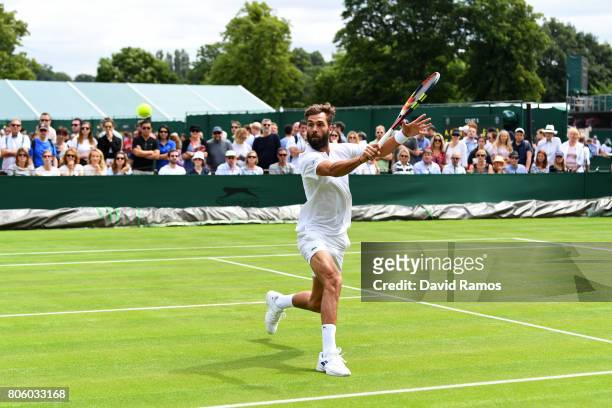 Benoit Paire of France plays a backhand during the Gentlemen's Singles first round match against Rogerio Dutra Silva of Brazil on day one of the...