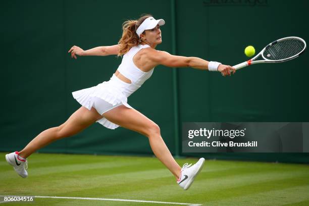 Alize Cornet of France stretches to play a backhand during the Ladies Singles first round match against Camila Giorgi of Italy on day one of the...