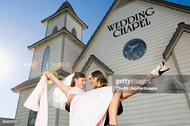 groom carrying bride out of chapel - vegas wedding stock pictures, royalty-free photos & images