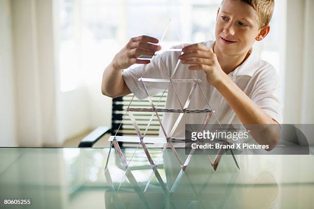 boy building house of cards - house of cards stock pictures, royalty-free photos & images