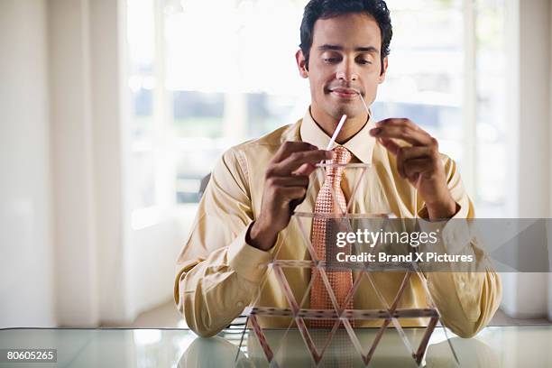 businessman building house of cards - house of cards stock pictures, royalty-free photos & images