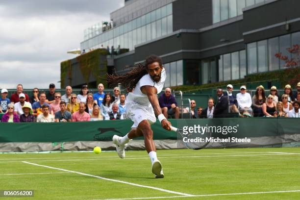 Dustin Brown of Germany plays a backhand during the Gentlemen's Singles first round match against Joao Sousa of Portugal on day one of the Wimbledon...