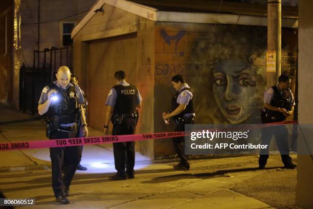 Chicago Police officers investigate the crime scene where a man was shot in the alley in the Little Village neighborhood on July 2, 2017 in Chicago,...