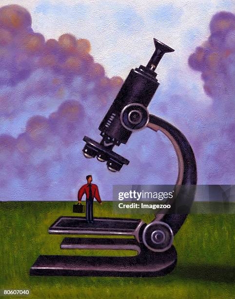 businessman standing underneath a microscope - kreuzverhör stock-grafiken, -clipart, -cartoons und -symbole