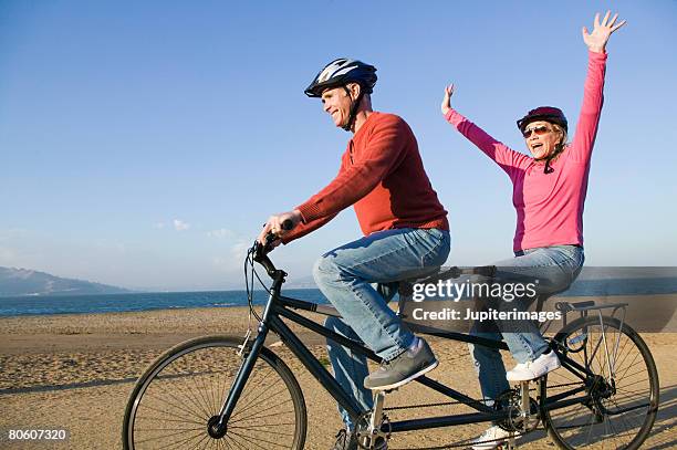 couple riding tandem bike - freihändiges fahrradfahren stock-fotos und bilder