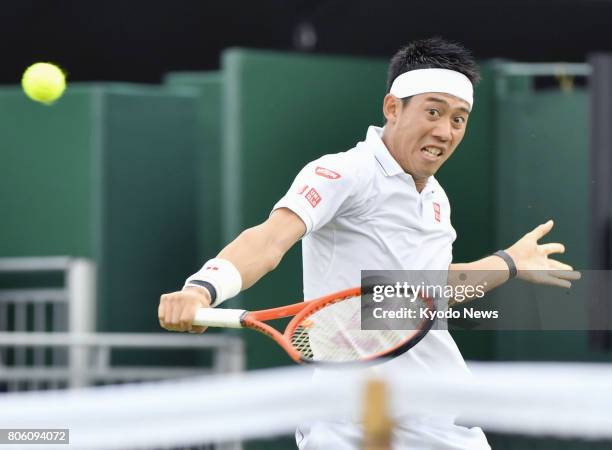 Kei Nishikori of Japan hits a backhand slice during his Wimbledon first-round match against Marco Cecchinato of Italy in London on July 3, 2017....