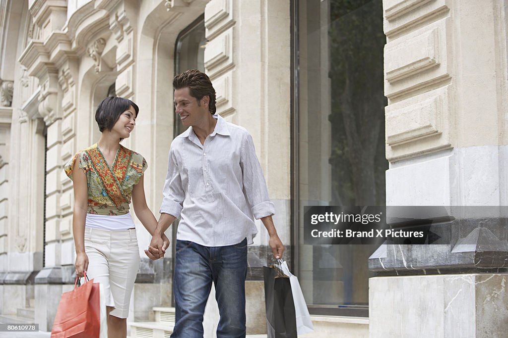 Couple with shopping bags holding hands