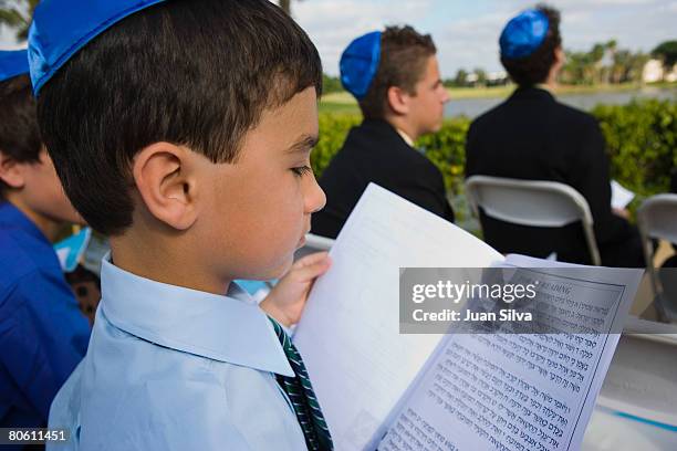 boy reading the torah at bar mitzvah - bar mitzvah stock pictures, royalty-free photos & images