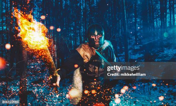 warrior with flaming torch walks through forest at nigth ready to attack - super strength stock pictures, royalty-free photos & images