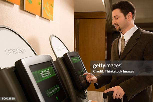 businessman using self check-in terminal - hotel kiosk stock pictures, royalty-free photos & images