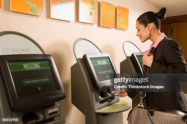 businesswoman using self check-in terminal - hotel kiosk stock pictures, royalty-free photos & images