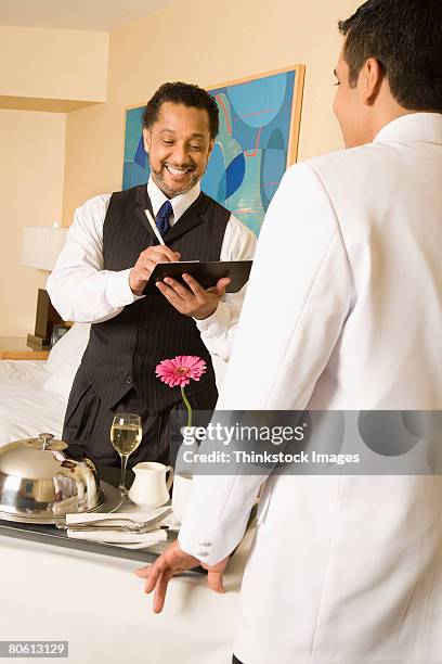 businessman paying bill for room service - serving cart stock pictures, royalty-free photos & images
