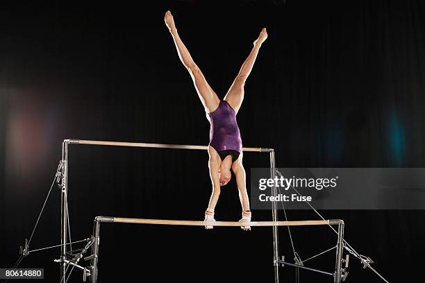 gymnast on uneven parallel bars - équilibre sur les mains photos et images de collection