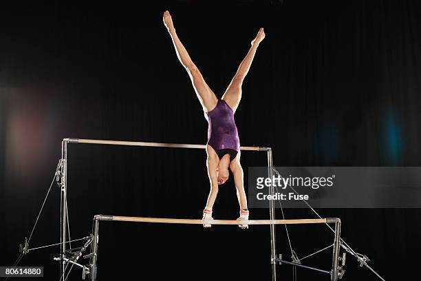 gymnast on uneven parallel bars - barras paralelas barra de ginástica - fotografias e filmes do acervo