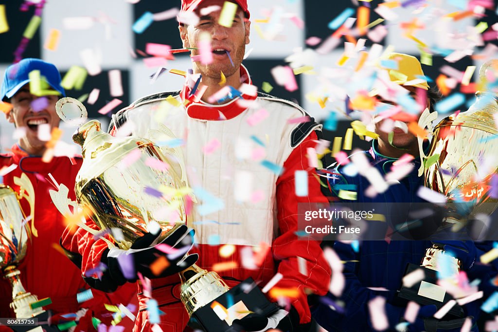 Racecar Driving Champions Holding Trophies